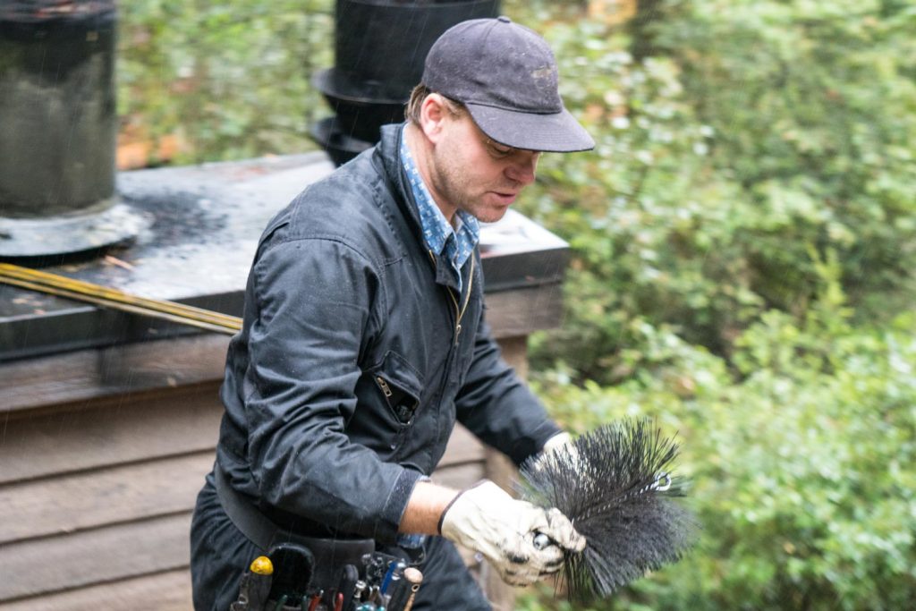 Man holding a chimney sweep brush