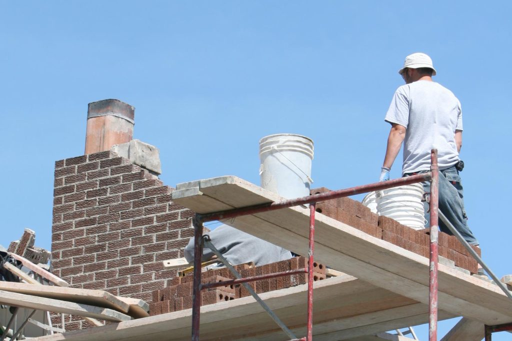 Man on a platform repairing a chimney