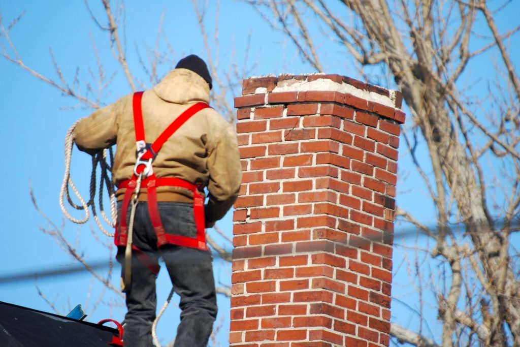 Man with harness close to the chimney
