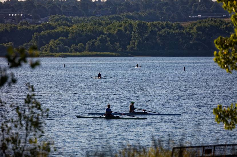 a picture of a silent lake with people on boats