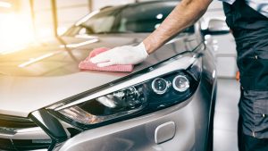 A man cleaning the black car