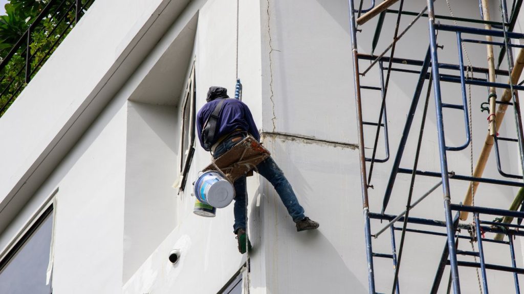 a worker doing an exterior paint job