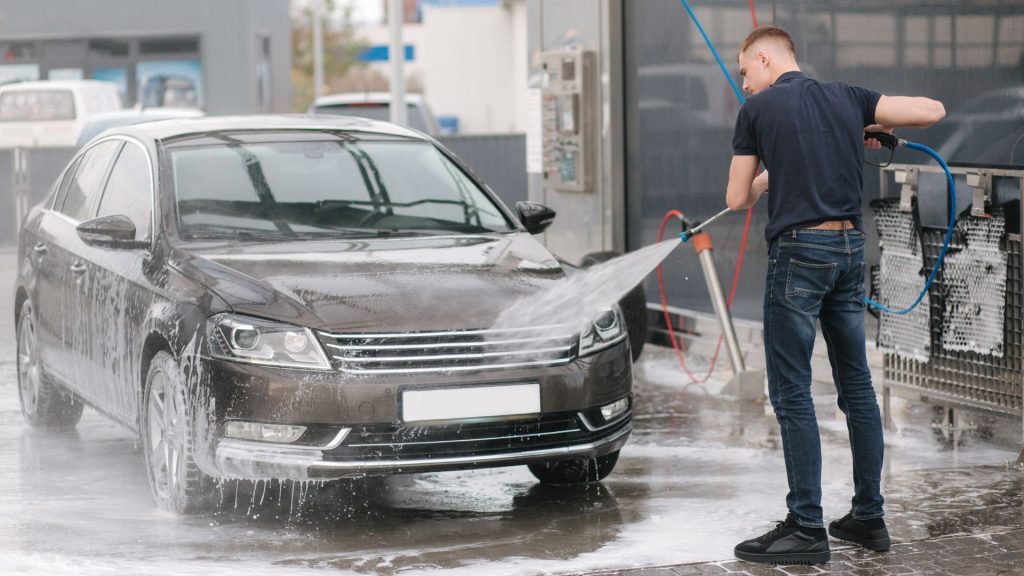 Man Cleaning Car with Pressure Washer
