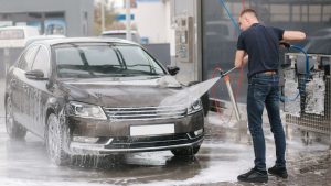Man Cleaning Car with Pressure Washer