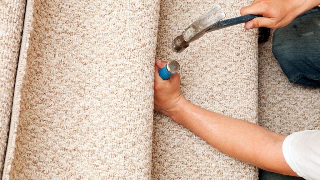 Man installing carpet on a stairs